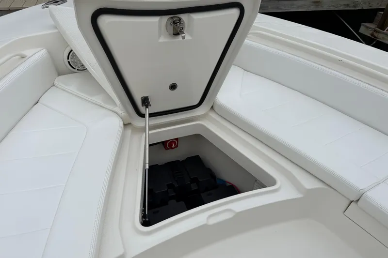 Slide: The Image of Open storage compartment on 2019 Regulator 26XO boat with white seating. - 11