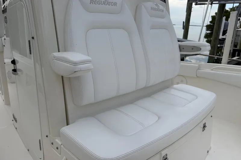 Slide: The Image of 2019 Regulator 26XO boat with white cushioned seating and armrests. - 16