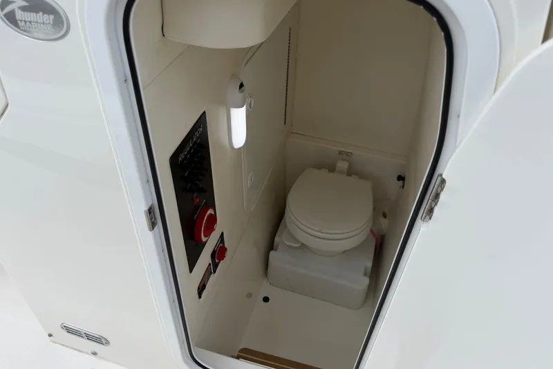 Slide: The Image of 2019 Regulator 26XO boat interior with compact marine toilet and control panel. - 22