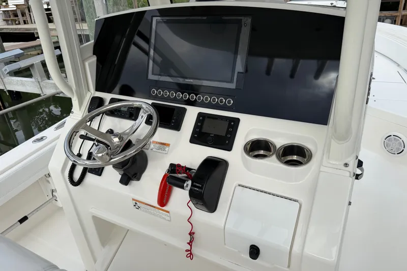 Slide: The Image of 2019 Regulator 26XO boat dashboard with steering wheel, controls, and display screen. - 27