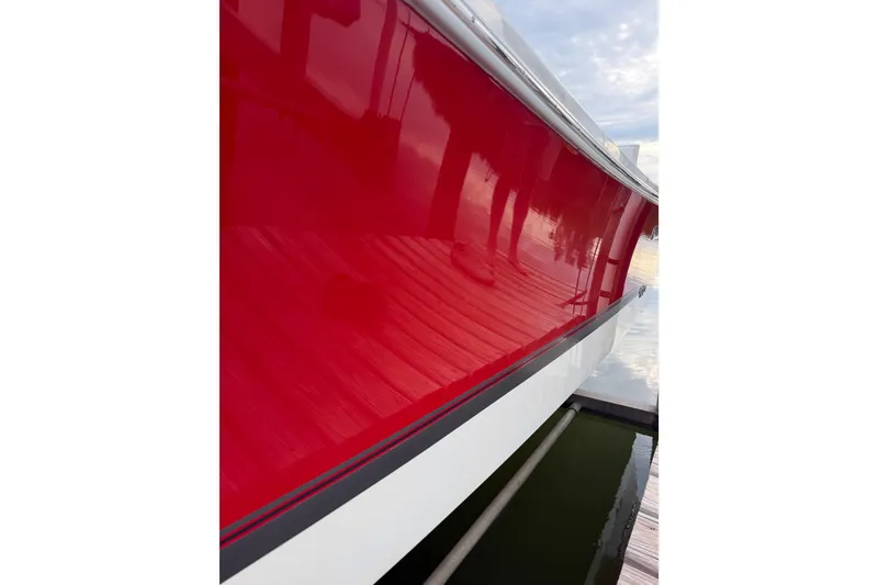 Slide: The Image of 2019 Regulator 26XO boat with a glossy red hull docked by the water. - 3