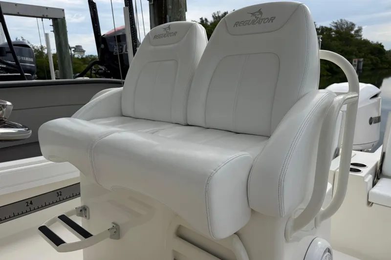 Slide: The Image of 2019 Regulator 26XO boat with white cushioned seating and Yamaha engines in background. - 30