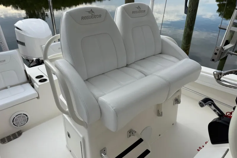 Slide: The Image of 2019 Regulator 26XO boat with white cushioned seating and Yamaha engine. - 31