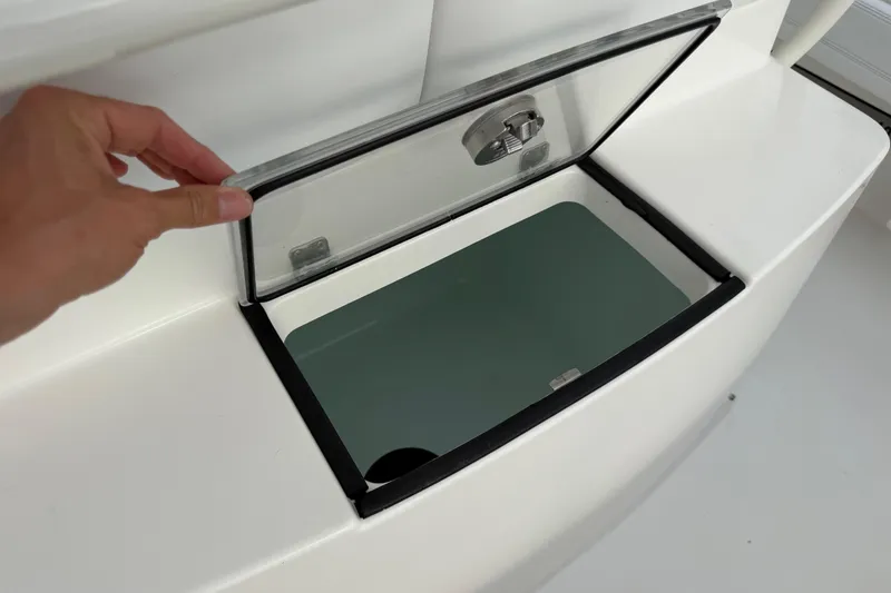 Slide: The Image of Hand opening storage compartment on 2019 Regulator 26XO boat. - 34