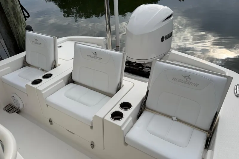 Slide: The Image of 2019 Regulator 26XO boat seats with Yamaha engine, docked by water. - 37