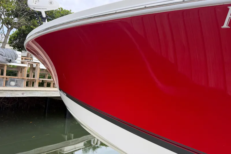 Slide: The Image of Red 2019 Regulator 26XO boat docked, showcasing sleek hull design. - 4