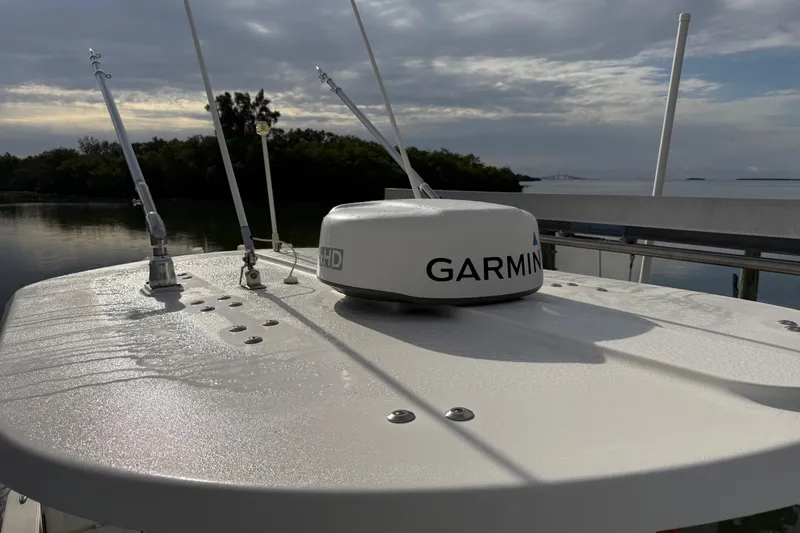 Slide: The Image of 2019 Regulator 26XO boat with Garmin radar, docked near lush greenery and calm waters. - 42