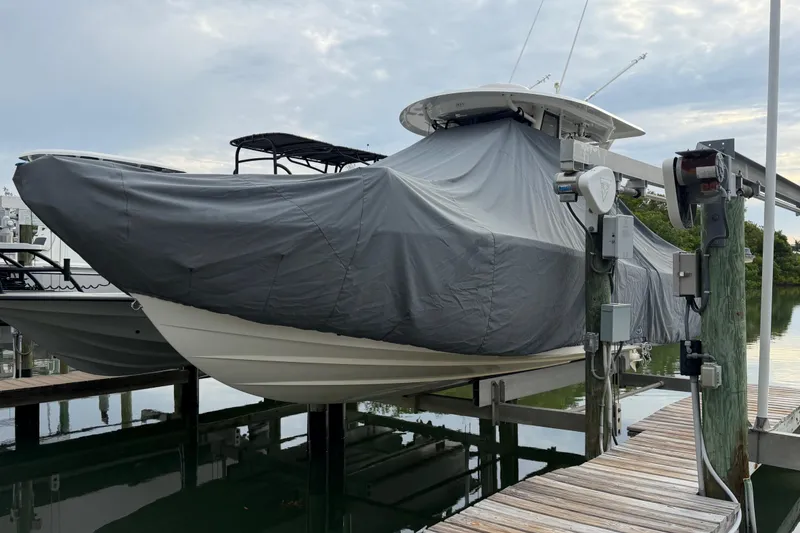 Slide: The Image of Covered 2019 Regulator 26XO boat on lift at dockside. - 49