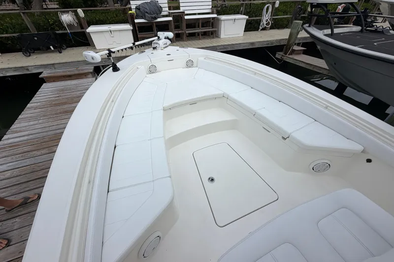 Slide: The Image of 2019 Regulator 26XO boat with spacious white seating and deck, docked at marina. - 6