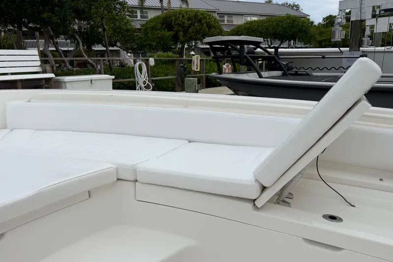 Slide: The Image of 2019 Regulator 26XO boat with white cushioned seating at a dock. - 9