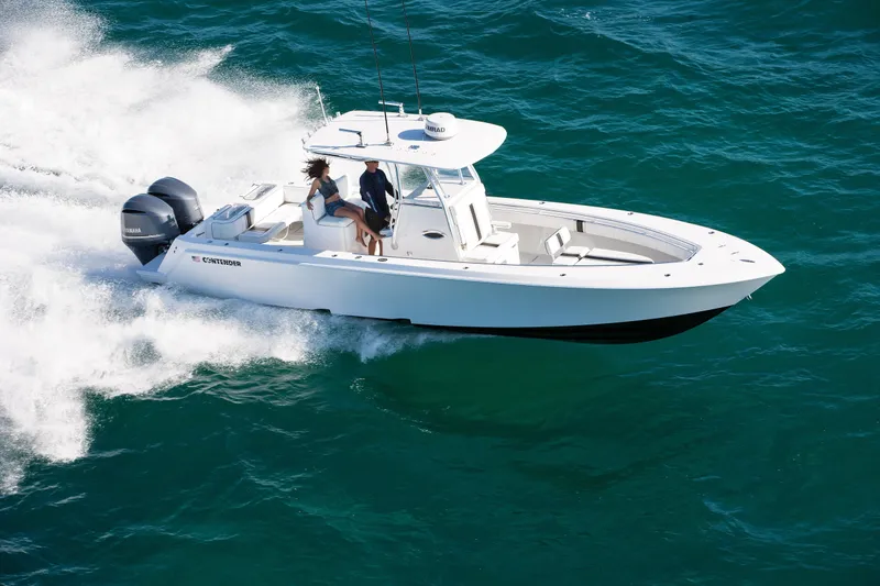 The Image of 2026 Contender 32 ST boat cruising on open water with two passengers. - 1