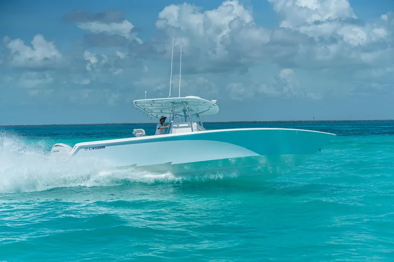 Slide: The Image of 2026 Contender 32 ST boat cruising on turquoise ocean waters under a cloudy sky. - 2