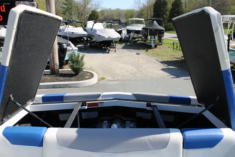 Slide: The Image of 2018 Malibu Wakesetter 23 LSV with open engine compartment at a boatyard. - 18