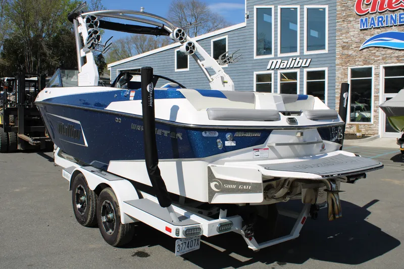 Slide: The Image of 2018 Malibu Wakesetter 23 LSV boat on trailer outside marine shop. - 3