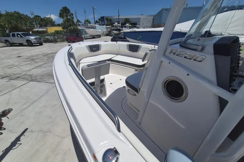 Slide: The Image of 2023 Robalo R230 Center Console boat with spacious seating, docked outdoors. - 13