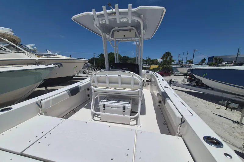 Slide: The Image of 2023 Robalo R230 Center Console boat with spacious deck and seating, parked outdoors. - 5