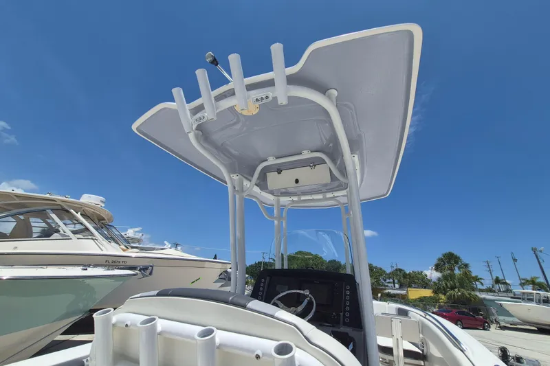 Slide: The Image of 2023 Robalo R230 Center Console boat with T-top under clear blue sky. - 8