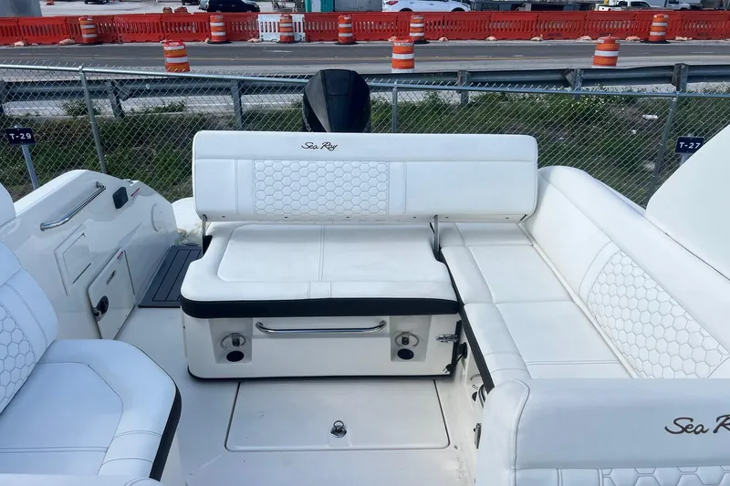 Slide: The Image of 2019 Sea Ray SDX 250 Outboard boat interior with white seating and hexagonal patterns. - 10