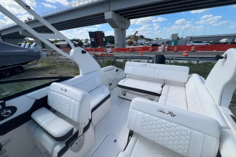 Slide: The Image of 2019 Sea Ray SDX 250 Outboard boat interior with white seating under a bridge. - 11