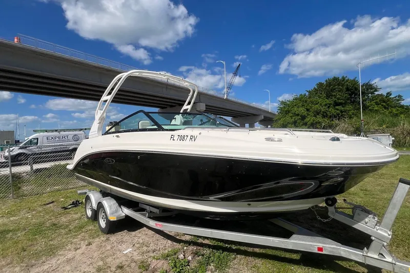 Slide: The Image of 2019 Sea Ray SDX 250 Outboard boat on trailer, under a bridge, sunny day. - 2