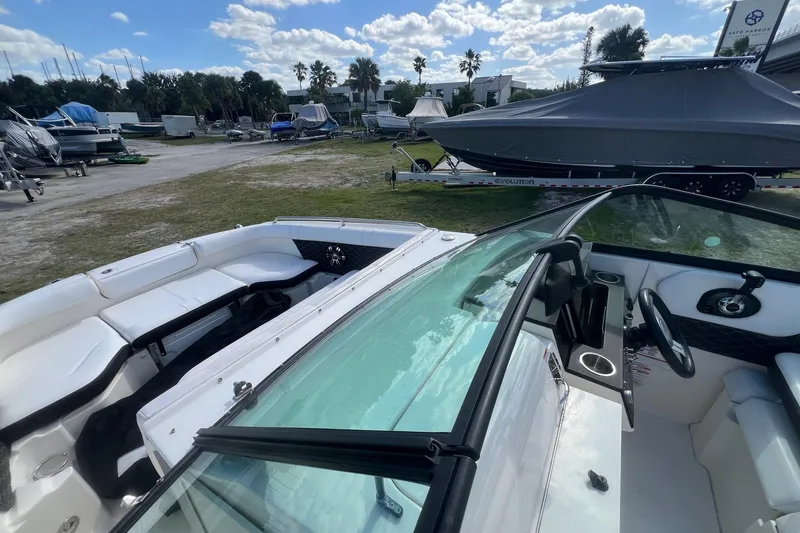 Slide: The Image of 2019 Sea Ray SDX 250 Outboard boat interior with seating and steering wheel, parked outdoors. - 8