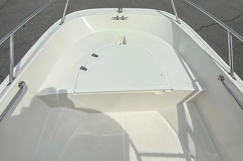 Slide: The Image of 2012 Boston Whaler 150 Super Sport boat interior with white deck and stainless steel rails. - 11
