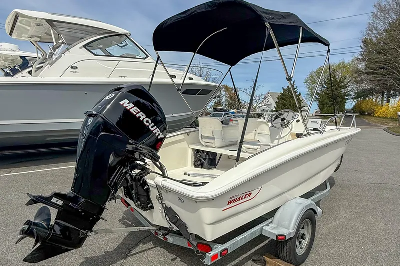Slide: The Image of 2012 Boston Whaler 150 Super Sport boat with Mercury engine on trailer. - 2