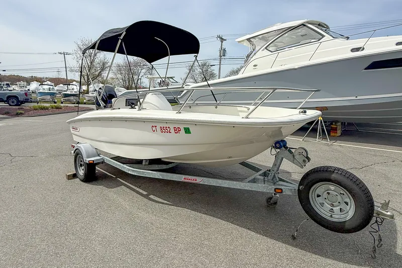 Slide: The Image of 2012 Boston Whaler 150 Super Sport boat on trailer, parked outdoors. - 4