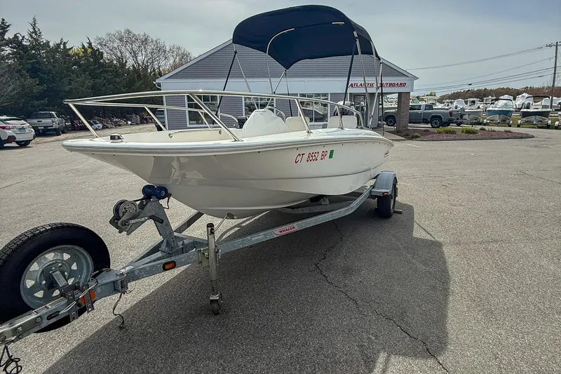 Slide: The Image of 2012 Boston Whaler 150 Super Sport boat on trailer in parking lot. - 5
