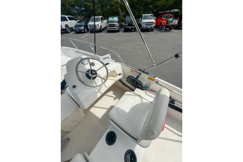 Slide: The Image of 2012 Boston Whaler 150 Super Sport boat interior with steering wheel and seating. - 8