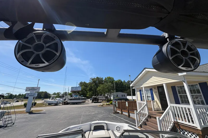 Slide: The Image of 2021 Yamaha Boats AR195 with mounted speakers, parked near a building under clear skies. - 14