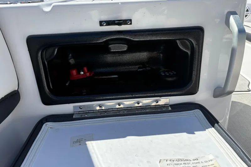 Slide: The Image of Open storage compartment on a 2021 Yamaha Boats AR195, featuring a red switch inside. - 16