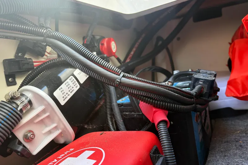 Slide: The Image of 2021 Yamaha AR195 boat engine compartment with wiring and battery connections. - 17