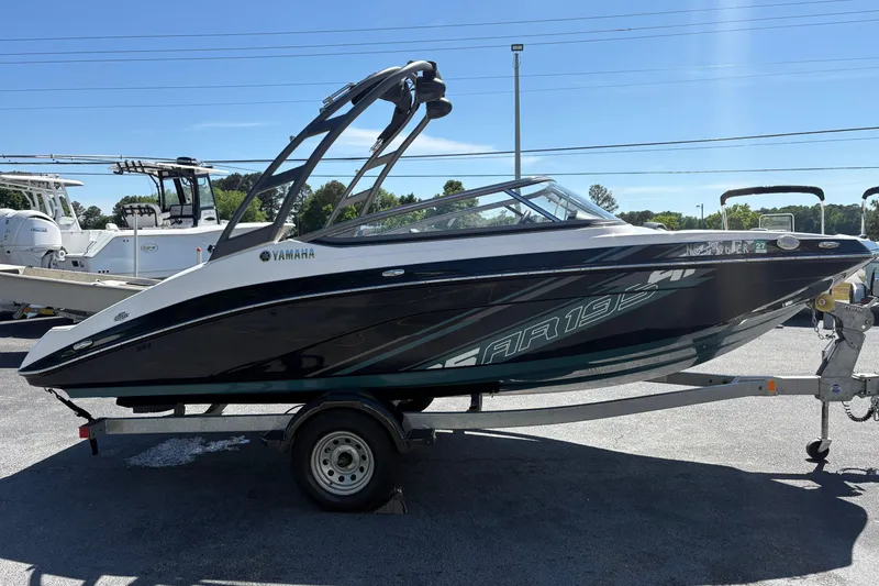 Slide: The Image of 2021 Yamaha AR195 boat on trailer, parked outdoors under clear sky. - 2