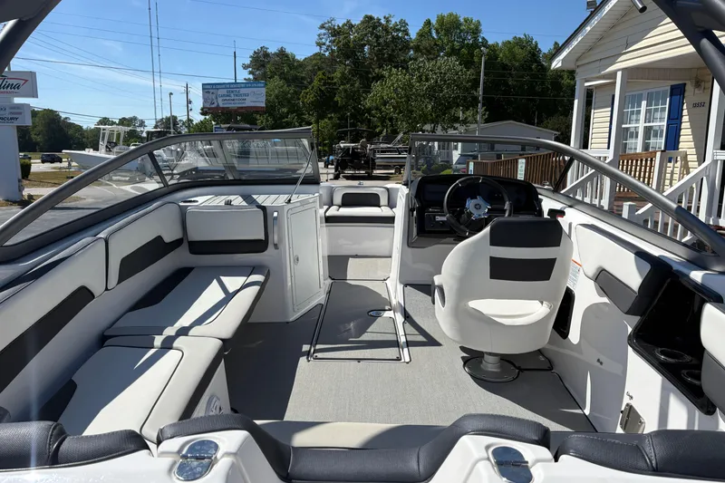 Slide: The Image of 2021 Yamaha Boats AR195 interior with seating and steering wheel, parked outdoors. - 8