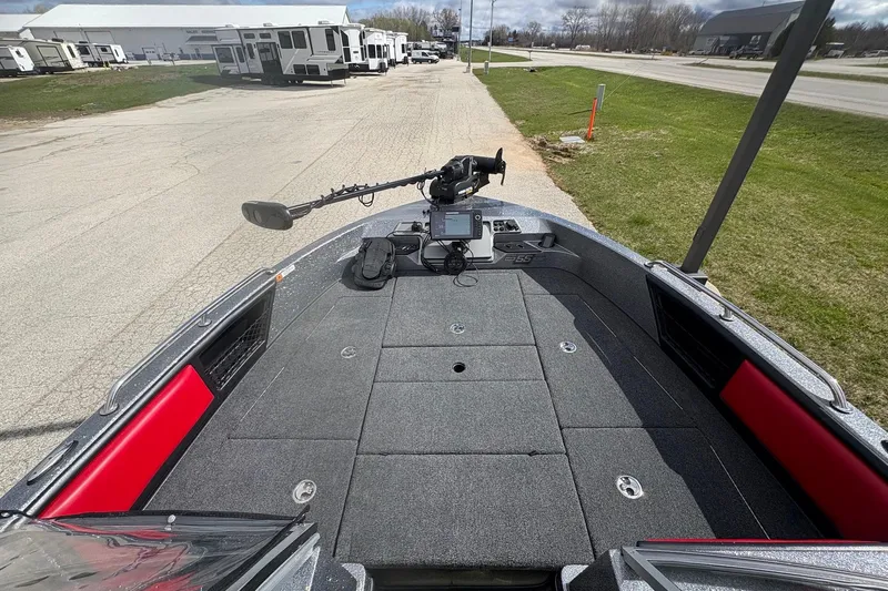 Slide: The Image of 2023 Ranger 2050MS boat deck with trolling motor and control panel, parked near RVs. - 12