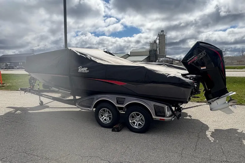 Slide: The Image of 2023 Ranger 2050MS boat on trailer with cover, parked outdoors under cloudy sky. - 3