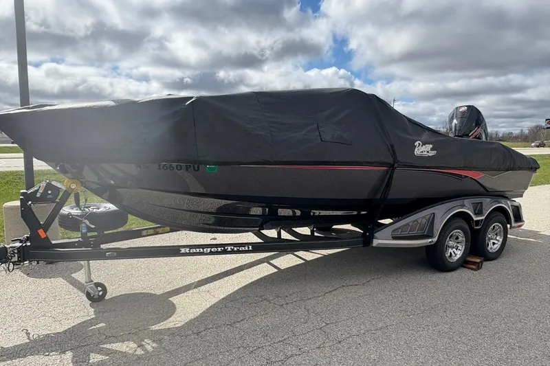 Slide: The Image of 2023 Ranger 2050MS boat on trailer, covered, parked outdoors under cloudy sky. - 4