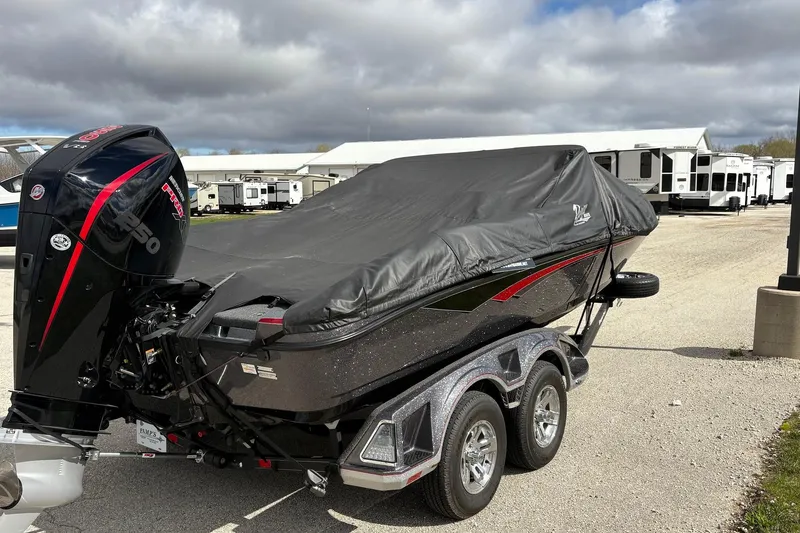 Slide: The Image of 2023 Ranger 2050MS boat with cover and powerful outboard motor in a parking area. - 6