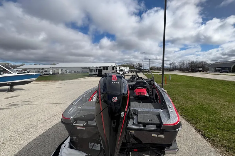 Slide: The Image of 2023 Ranger 2050MS boat with powerful engine, parked outdoors under cloudy sky. - 7