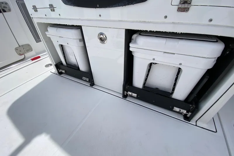 Slide: The Image of Storage compartments on a 2022 Blackfin 332 CC boat, featuring two white coolers. - 16