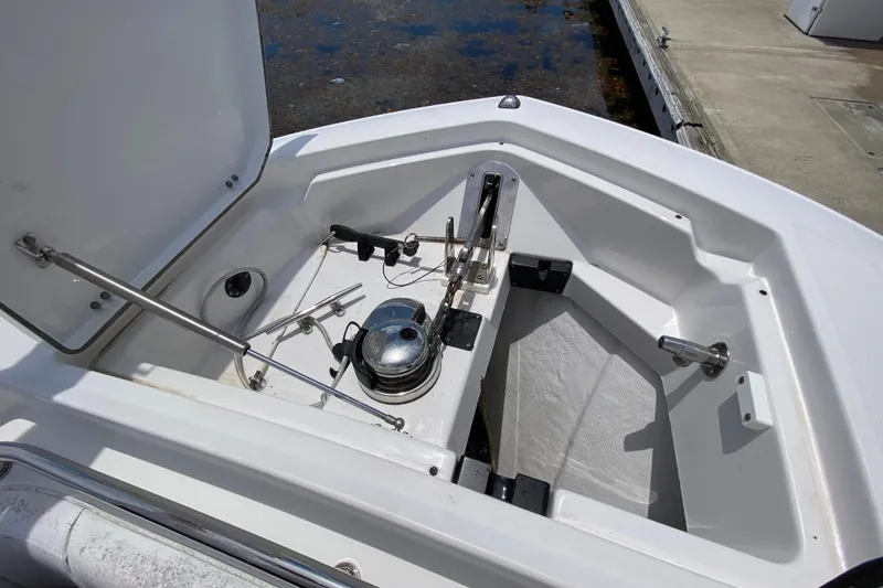 Slide: The Image of 2022 Blackfin 332 CC boat anchor compartment with open hatch, showcasing marine hardware. - 24