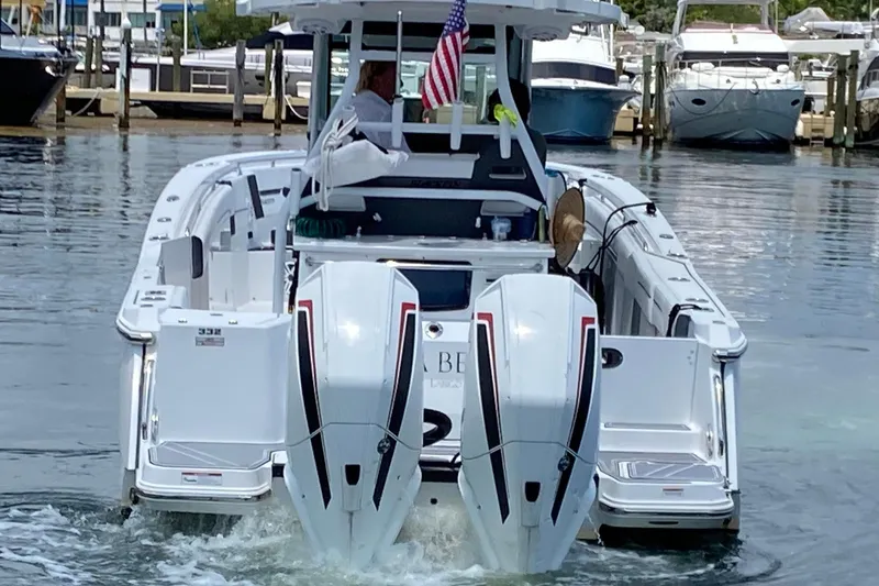 Slide: The Image of 2022 Blackfin 332 CC boat with dual engines, docked in a marina. - 3