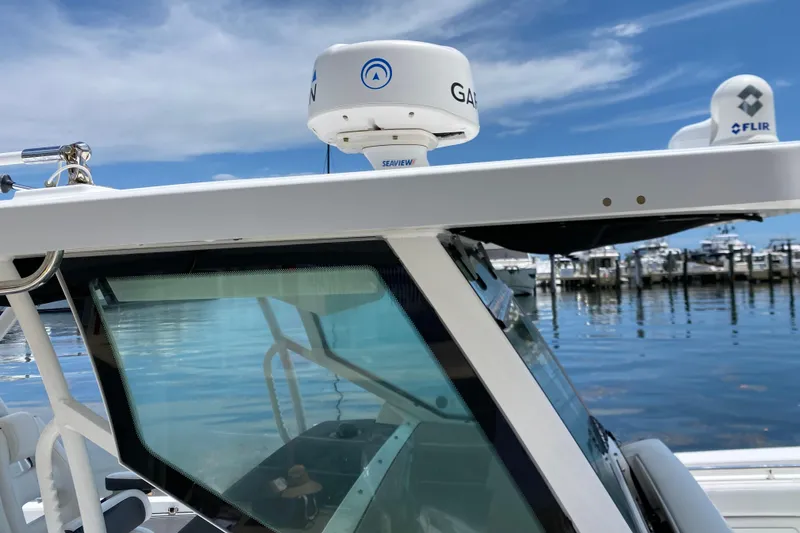 Slide: The Image of 2022 Blackfin 332 CC boat with Garmin radar, docked at marina under blue sky. - 30