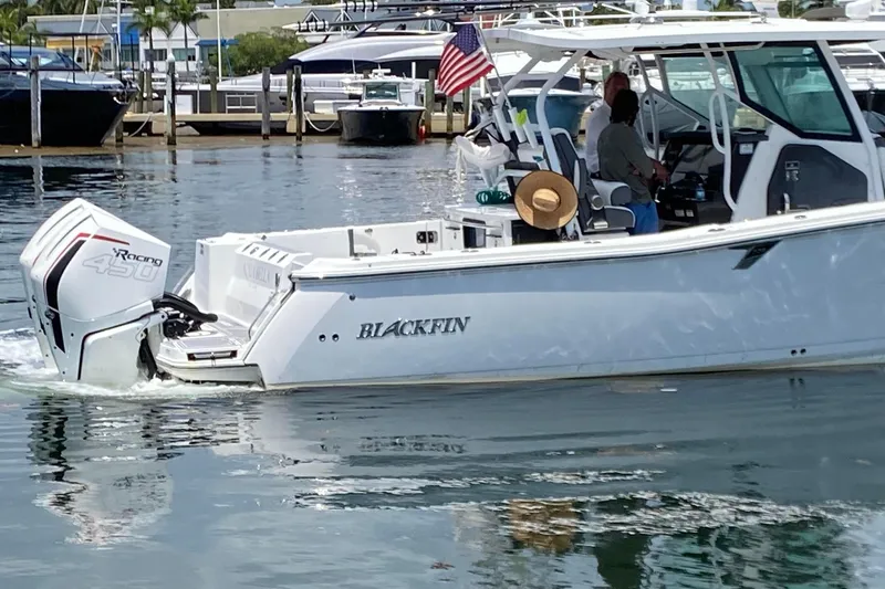Slide: The Image of 2022 Blackfin 332 CC boat with powerful outboard engine cruising in marina. - 5