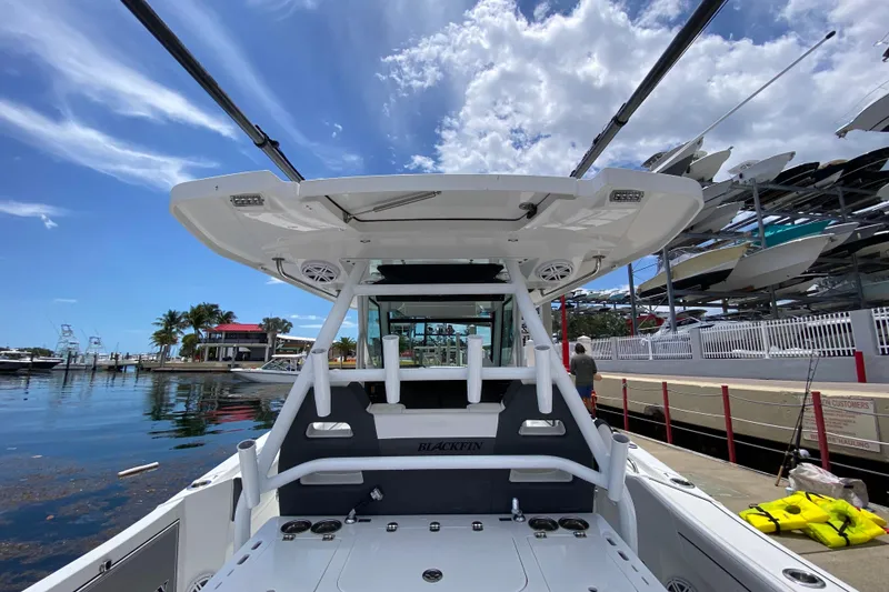 Slide: The Image of 2022 Blackfin 332 CC boat docked under a clear blue sky. - 7