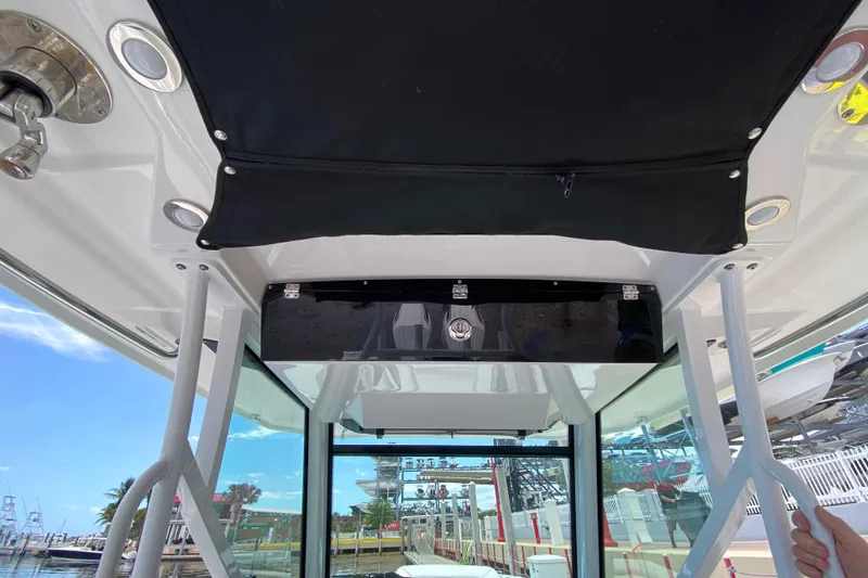 Slide: The Image of Interior view of a 2022 Blackfin 332 CC boat, showcasing the overhead compartment and canopy. - 9