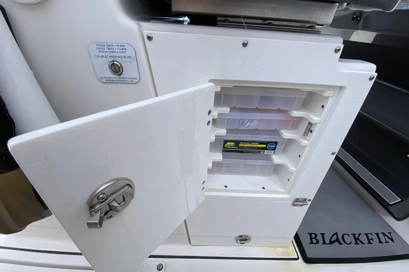 Slide: The Image of Open storage compartment on 2022 Blackfin 332 CC boat with tackle boxes inside. - 15