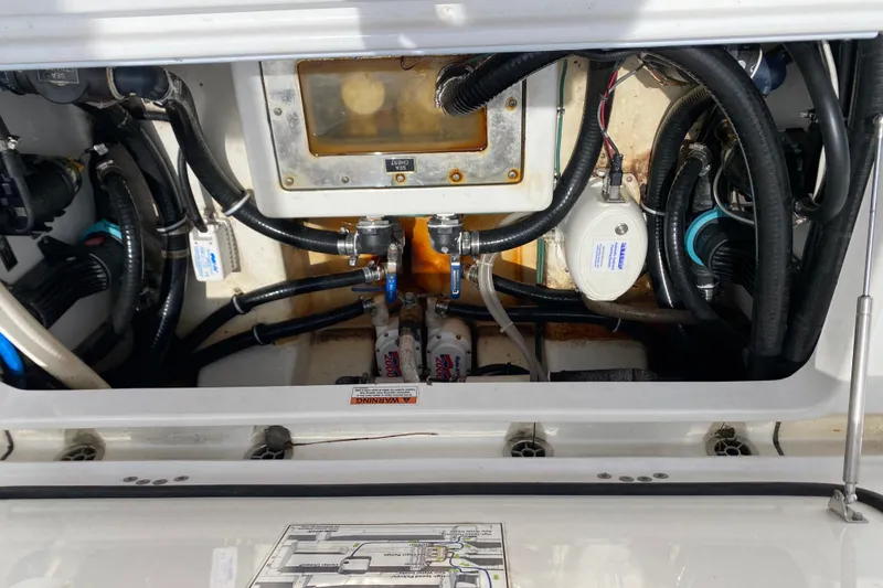Slide: The Image of Engine compartment of a 2022 Blackfin 332 CC boat, showcasing hoses and mechanical components. - 19
