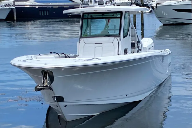 Slide: The Image of 2022 Blackfin 332 CC boat docked in a marina, showcasing sleek design and modern features. - 2